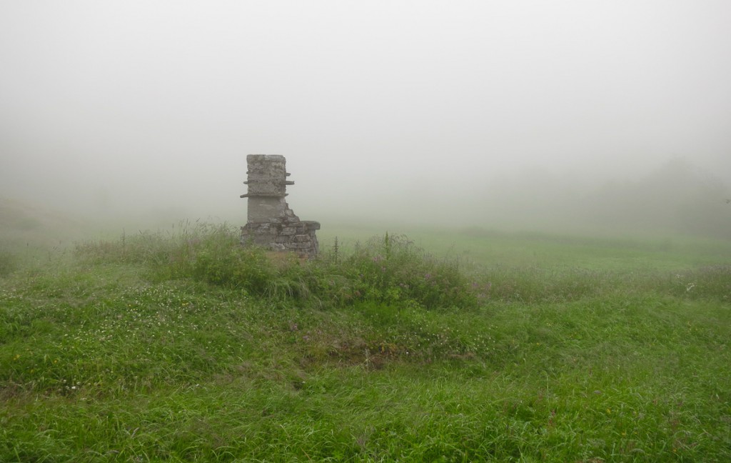 foggy green field with old chimney